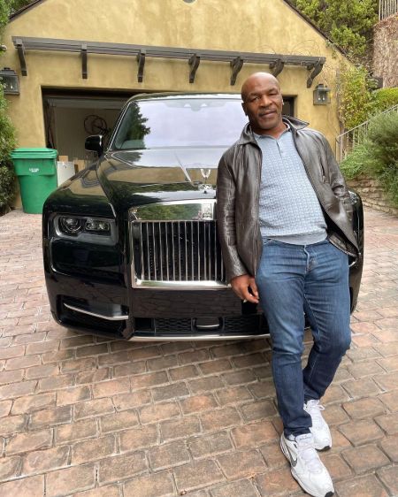 He is posing for a photo with his car.